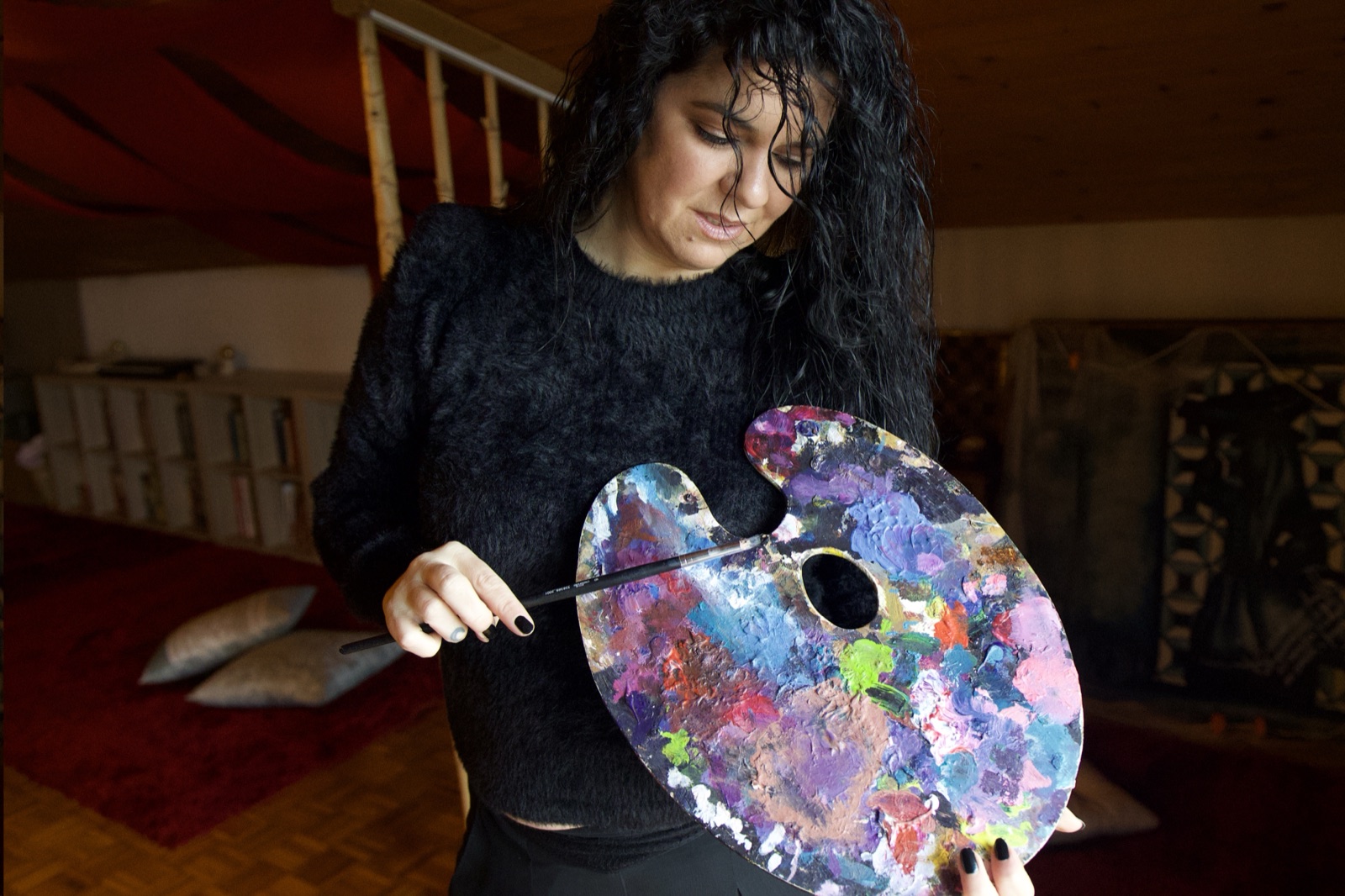Marina Leão no atelier com a paleta de tintas
